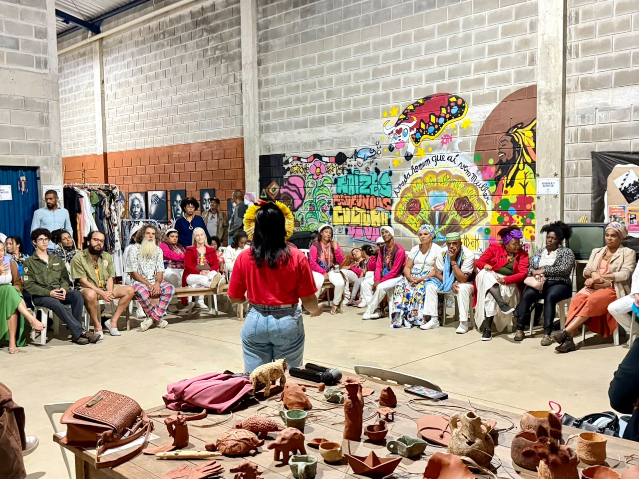 Roda de conversa do ITA com participantes, obras artesanais e arte urbana
